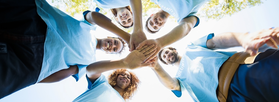 Community Parent Volunteer Lead Image Five people joining hands to show their support for one another.