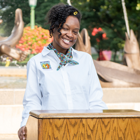 Best Buddies Monthly giving Leadership Development image A female Buddy Ambassador standing at a podium delivering a speech